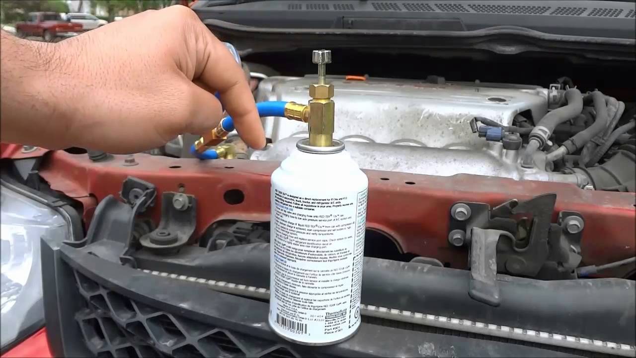 Freon refill technician servicing an air conditioning unit in London